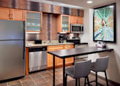 Thumbnail 3 of 18 - A kitchen with a refrigerator, oven, microwave, and dishwasher at Fusion Buckhead Apartments.