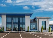 Thumbnail 20 of 27 - The Canvas Apartments Nashville modern leasing office building with a blue roof and glass doors.