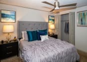 Thumbnail 11 of 49 - Bedroom in the Retreat at Indian Lake apts in Hendersonville with modern ceiling fan and queen bed with fabric headboard and luxury duvet and velvet pillows.