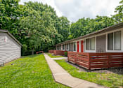 Thumbnail 27 of 36 - A long row of studio and one bedroom apartments in Hendersonville TN with a sidewalk in between.
