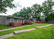 Thumbnail 24 of 36 - A row of apartments at The Retreat at Indian Lake studio and 1 bedroom apartments in Hendersonville with green grass in front.