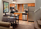 Thumbnail 4 of 18 - A kitchen with a refrigerator, stove, and sink at Fusion Buckhead.