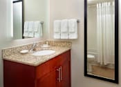 Thumbnail 5 of 18 - A bathroom with a counter, sink, mirror, toilet, and towels at Fusion Buckhead Apartments.