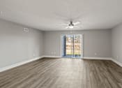 Thumbnail 7 of 38 - A living room with a ceiling fan and sliding glass doors at Mandarin Bay Apartments.