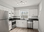 Thumbnail 4 of 38 - A kitchen with white cabinets and a stainless steel refrigerator at Mandarin Bay Apartments.