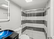 Thumbnail 12 of 38 - A bathroom with a toilet, sink, and shower at Mandarin Bay Apartments.