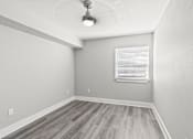 Thumbnail 33 of 38 - A room with a window and wooden flooring.
