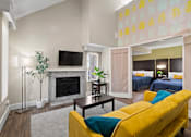 Thumbnail 2 of 41 - A living room with a yellow couch and a fireplace.