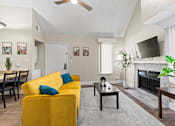 Thumbnail 1 of 41 - A living room with a yellow sofa and a fireplace at Fusion Orlando furnished apartments.
