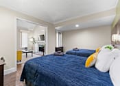 Thumbnail 6 of 41 - Fusion Orlando furnished bedroom with two large beds and an opening to the living room.