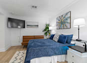 Thumbnail 13 of 41 - A bedroom with a blue comforter on the bed.