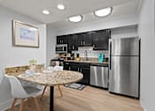 Thumbnail 14 of 41 - A kitchen with a granite table and a refrigerator.
