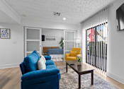 Thumbnail 10 of 41 - A living room with a blue chair and a yellow chair.