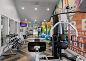 Thumbnail 23 of 41 - Fusion Orlando fitness center with a variety of equipment including a weight bench, dumbbells, and a treadmill.
