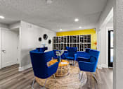 Thumbnail 30 of 41 - A living room with blue chairs and a wicker table.