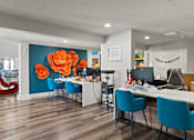 Thumbnail 29 of 41 - A room with a desk and chairs and a flower on the wall at the Fusion Orlando apartments leasing office