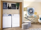 Thumbnail 14 of 27 - a laundry room with a washer and dryer and a living room with furniture