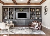 Thumbnail 8 of 28 - A seating area with two white chairs and two brown chairs on a rug, on hardwood-style flooring.