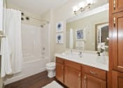 Thumbnail 8 of 25 - An updated modern bathroom includes a relaxing soaking tub and practical storage space.