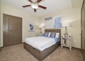 Thumbnail 5 of 25 - A spacious bedroom in a two-bedroom apartment at Austin Park Apartments includes carpet flooring, a ceiling fan, and a convenient closet.
