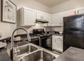 Thumbnail 1 of 29 - a kitchen with white cabinets and black appliances