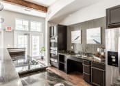 Thumbnail 24 of 28 - A communal kitchen at The Fort with stainless steel appliances, modern decor, and a large window.
