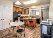 Thumbnail 24 of 55 - Arbors at Turnberry Apartments Pickerington Ohio Pet Friendly Updated Modern Kitchen wood style flooring, stone style countertops, kitchen island, dining area, and pantry