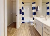 Thumbnail 10 of 29 - a bathroom with white cabinets and a blue and white striped shower curtain