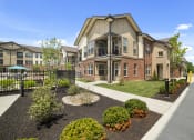 Thumbnail 23 of 25 - The exterior of Austin Park Apartments in Miamisburg, Ohio features attractive, well-lit landscaping and ample parking spaces for residents and guests.