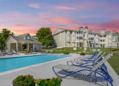 Thumbnail 5 of 19 - Resort-style pool at The Boulevard in Florence, KY with a sundeck, lush landscaping, and lounge seating