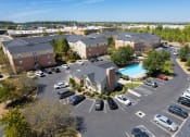 Thumbnail 26 of 27 - an aerial view of an apartment complex with a swimming pool and parking lot