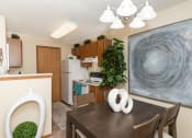 Thumbnail 3 of 27 - a dining area with a table and chairs and a kitchen in the background