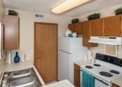 Thumbnail 9 of 27 - One-Bedroom Apartments in Hilliard, OH - Residences at Breckenridge - Kitchen With Wood-Style Cabinetry, Electric Stove, Refrigerator, and Dual Sinks