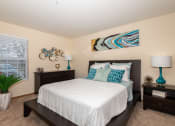 Thumbnail 2 of 27 - 2-Bedroom Apartments in Hilliard, OH - Residences at Breckenridge - Spacious Bedroom with Carpet Flooring, Bed, Dresser, Nightstands, Lamps, and a Window