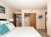 Thumbnail 10 of 27 - a bedroom with a large bed and a bathroom in the background
