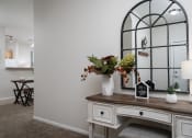 Thumbnail 12 of 21 - Decorative console table with a floral arrangement, adding a welcoming touch to a Catalina Club apartment entryway.