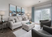 Thumbnail 1 of 21 - One-bedroom apartment living room at Catalina Club in Pataskala, OH, featuring plush carpeting, modern furnishings, and access to a private patio through sliding glass doors.