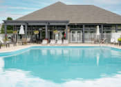 Thumbnail 17 of 21 - Sparkling swimming pool at Catalina Club with umbrella-covered seating and a beautiful building backdrop.