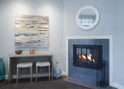 Thumbnail 12 of 19 - Living area with a fireplace, casual seating, and a bistro-style table with two stools
