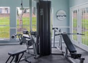 Thumbnail 15 of 19 - Apartment community gym with various exercise equipment and natural light from large windows