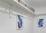 Thumbnail 10 of 19 - Minimalist room with white walls and abstract blue artwork