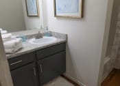 Thumbnail 11 of 19 - Bright bathroom featuring a mirror, sink, and toilet with neutral finishes