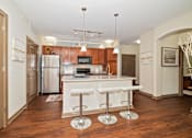 Thumbnail 25 of 25 - The updated modern interior of a kitchen showcases hardwood flooring and granite-style countertops.
