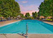 Thumbnail 4 of 27 - Apartments in Hilliard, OH, for Rent - Residences at Breckenridge - Pool Surrounded by Lounge Chairs and Lush Greenery