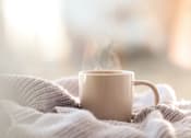 Thumbnail 42 of 55 - A cup of coffee is steaming on a cozy blanket.