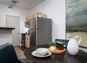 Thumbnail 8 of 25 - Dining area with table and chairs, adjacent to a kitchen featuring stainless steel appliances at The Coleman