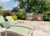 Thumbnail 18 of 25 - Outdoor patio with grill and two lounge chairs, perfect for relaxing at The Coleman