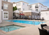 Thumbnail 2 of 28 - The Fort swimming pool with chairs and a red umbrella, and a black fence.