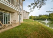 Thumbnail 18 of 19 - Charming patio area with a table and two chairs beside a serene water feature