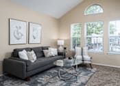 Thumbnail 6 of 23 - 2 BR Apartments in Florence KY - Windridge Townhomes - Living Room with Carpet Flooring, Area Rug, Sofa, Chair, Coffee Table, End Table, Lamp, and Windows